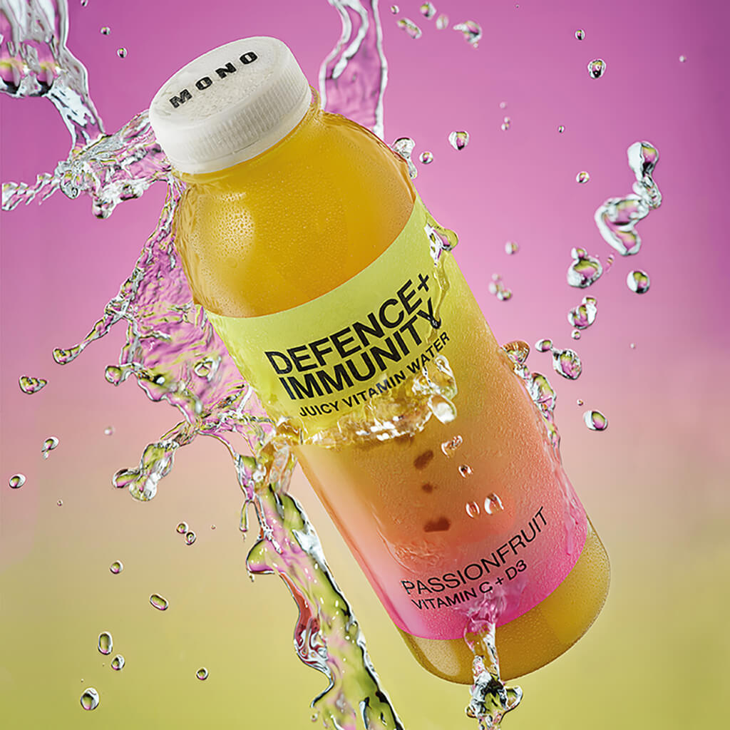 MONO Juicy Vitaminwater Defence + Immunity vor gelb-violetten Hintergrund 